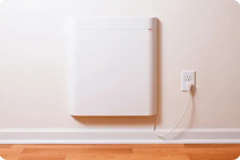 Un radiateur électrique blanc, moderne et discret, est branché à une prise murale. Ce type de radiateur est une solution de chauffage efficace.