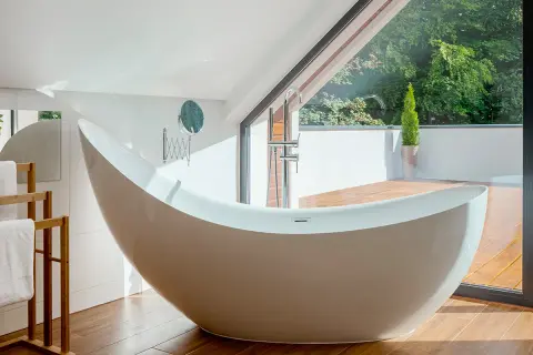 Baignoire îlot moderne, en acier ou acrylique, avec vue sur la nature.
