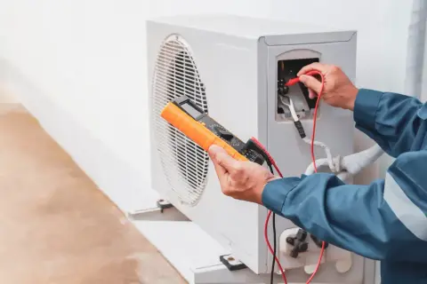 Un technicien vérifie une pompe à chaleur, une solution moderne pour remplacer le chauffage électrique.