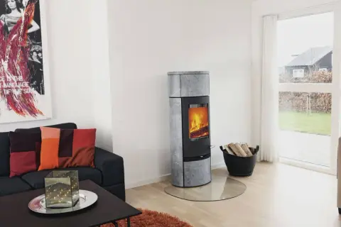 Un poêle à bois moderne, idéal pour installer un poêle à bois dans une maison sans conduit, chauffe agréablement le salon.