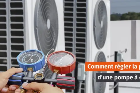 Main d'un technicien ajustant la pression eau pompe à chaleur avec un manomètre.